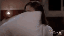 a woman is covering her face with a pillow from the hallmark channel