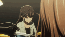 a girl in a white jacket is playing drums in a dark room