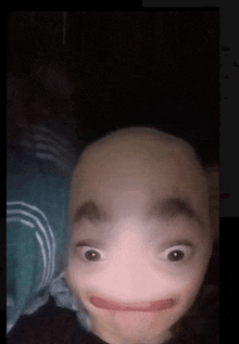 a person with a shaved head is making a funny face with their mouth open .