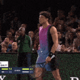 a tennis player wipes his nose with a towel while holding a racquet