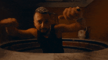 a man with a beard is standing in a bathtub with his fist in the air