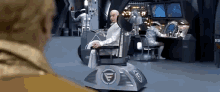a man is sitting in a chair with the letter g on the side .