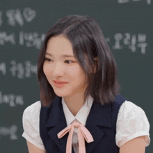 a girl wearing a white shirt and a blue vest with a pink bow