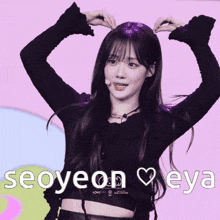 a girl making a heart shape with her hands and the words seoyeon eya