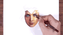 a person is drawing a woman 's face with a pencil on a piece of paper