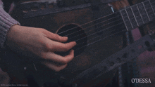 a close up of a person playing a guitar with the words odessa on the bottom