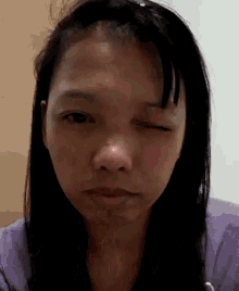 a close up of a girl 's face with one eye closed