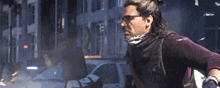 a man wearing glasses and a bandana stands in front of a white police car