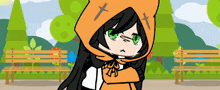 a girl with green eyes is wearing an orange hoodie with crosses on it .