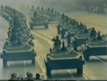 a group of military vehicles are driving down a street
