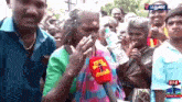 a woman is holding a bottle of water in front of a crowd .