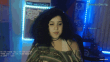 a happy halloween sign hangs on a wall behind a woman