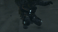 a man in a space suit is kneeling down and holding a camera .