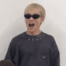a man wearing sunglasses is making a funny face .