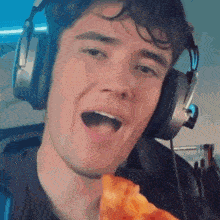 a man wearing headphones holds a slice of pizza