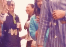 a group of people are standing next to each other at a party and dancing .