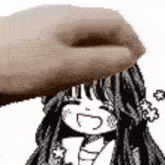 a hand is touching a cartoon girl 's head .