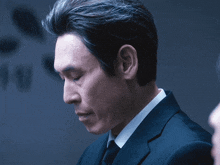 a man in a suit and tie is looking down at something