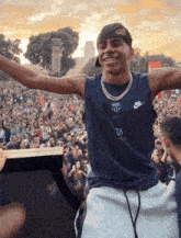 a man wearing a nike shirt with the number 28 on it stands in front of a crowd