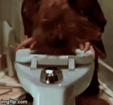 a person is sitting on a toilet with their head down