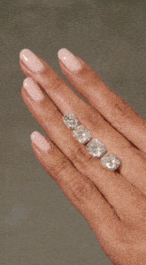 a woman 's hand with pink nails and a diamond ring on her finger