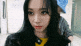 a woman with long black hair is wearing a yellow shirt and a black leather jacket .