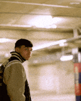 a man wearing a varsity jacket is standing in a parking garage with the words canirove visible in the corner