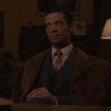 a man in a suit and tie sitting at a table