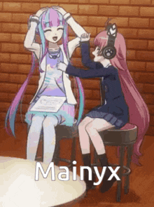 two anime girls are sitting next to each other and one of them is putting headphones on another girl 's head .