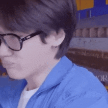 a close up of a person wearing glasses and a blue jacket
