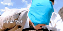 a person with a blue bandana on their head with korean writing on it
