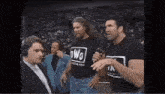 a group of men standing next to each other in a wrestling ring .