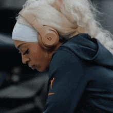a woman wearing a headband and headphones has the number 6 on her head