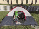 a gif from gifsboom.net shows a boy in a green shirt playing in a tent