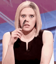 a woman is holding a pen in her mouth and making a funny face .