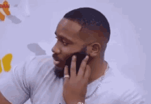a man with a beard is making a funny face with his hands .
