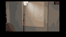 a room with a shutter on the wall and a light on a stand