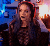 a woman wearing headphones and a black shirt is sitting in front of a bed