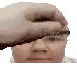 a hand is covering a man 's face with a piece of paper .