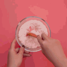 a flamingo donut with pink frosting and pink shredded paper around it