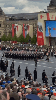 a large crowd of people watching a parade with a sign that says 1945