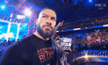 a man with a beard is standing in front of a crowd in a stadium holding a sign that says not good .