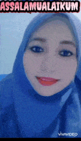 a woman wearing a blue hijab is smiling with the words assalamualaikum above her