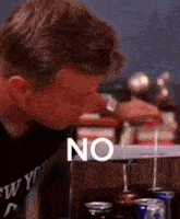 a man in a new york shirt is drinking from a can of soda