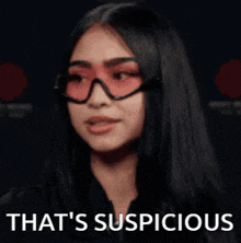 a woman wearing red sunglasses and a black jacket is saying that 's suspicious .