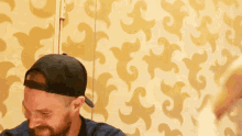 a man with a beard is wearing a black hat