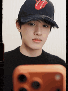 a young man wearing a black hat with the rolling stones logo