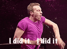 a man in a purple shirt is singing into a microphone and says " i did it "