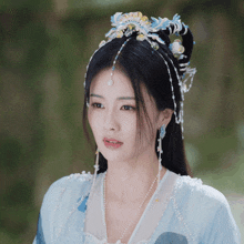 a woman wearing a blue dress and a headpiece with blue and yellow beads