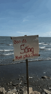 a sign on the beach says ban da song hạnh phúc dua